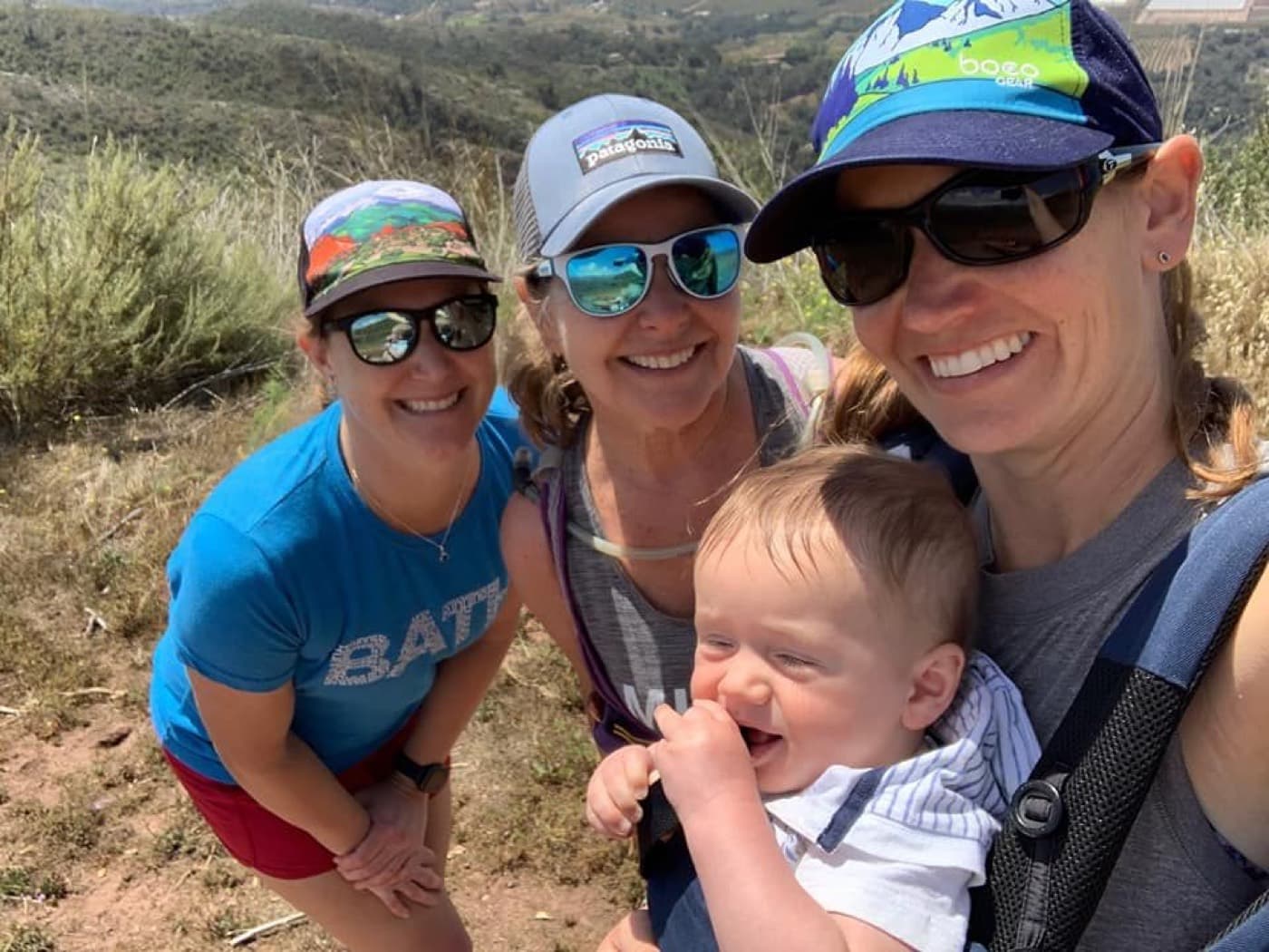 Three club members with a baby in a carrier